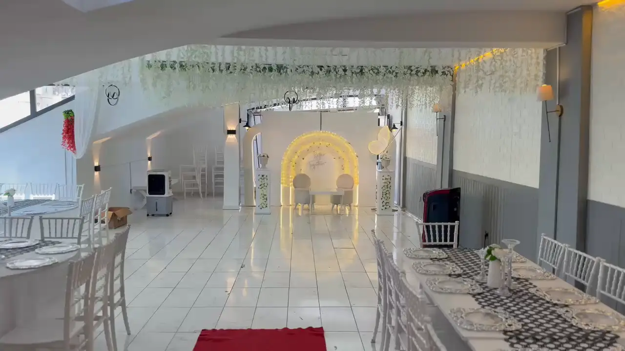 Belinay Davet Evi salonu: mermer zemin, beyaz sandalyeler ve ışıklı nikâh kemeri